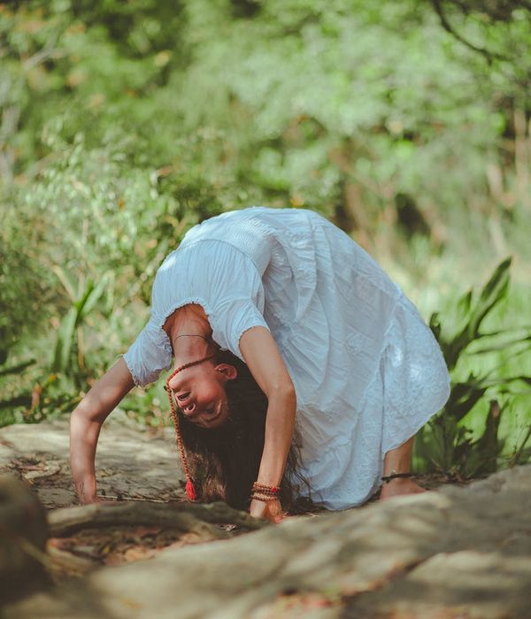 Woman performing a calm yoga pose in a bright, serene environment.